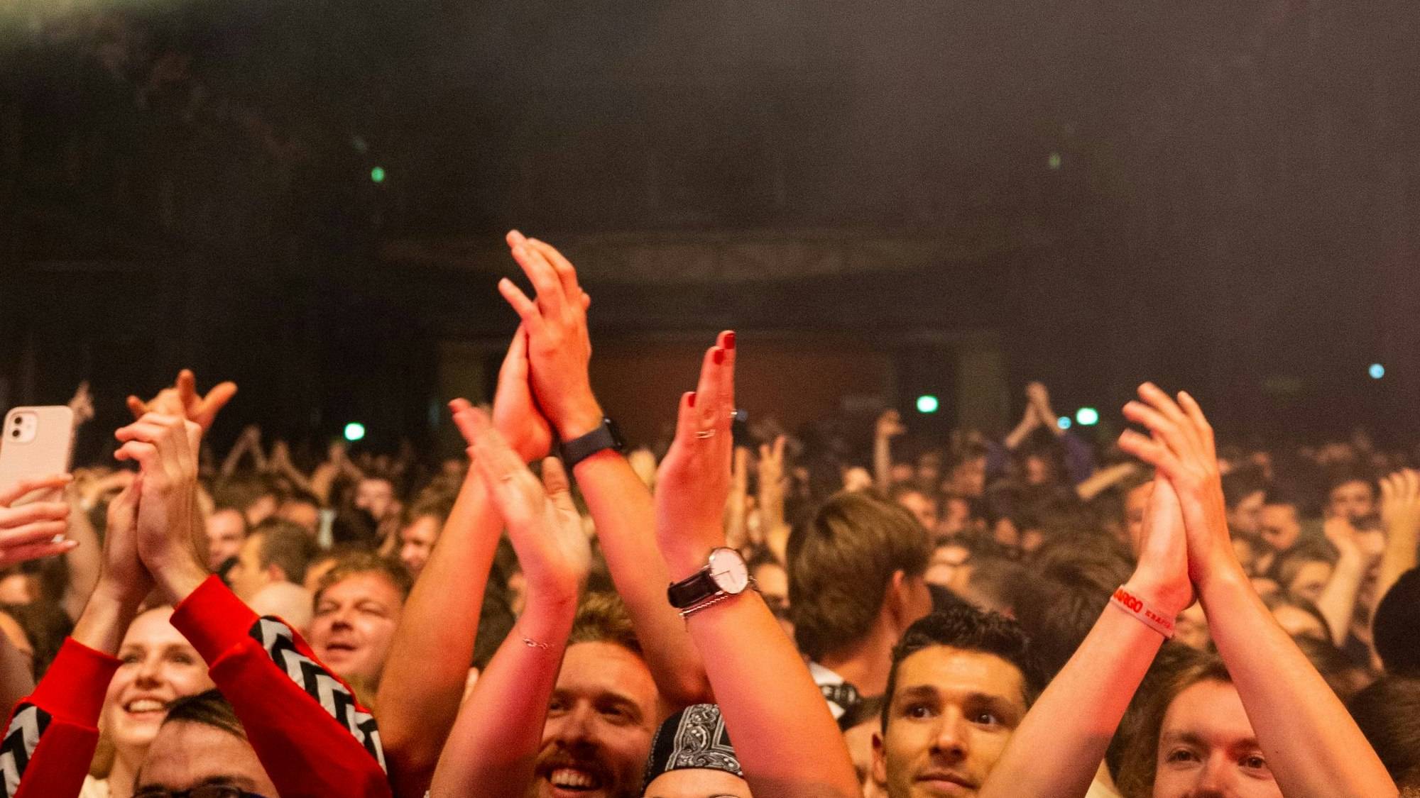 Das Publikum streckt die Hände in die Luft.