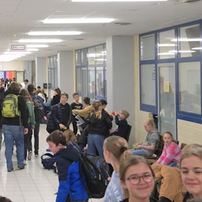Schülerinnen und Schüler des Gymnasiums Herkenrath in Bergisch Gladbach sitzen in einem Gang.