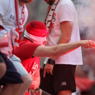 Ein Kölner Fan mit Pyrotechnik auf der Südtribüne beim Bundesliga-Spiel gegen den VfL Wolfsburg (Archivbild)