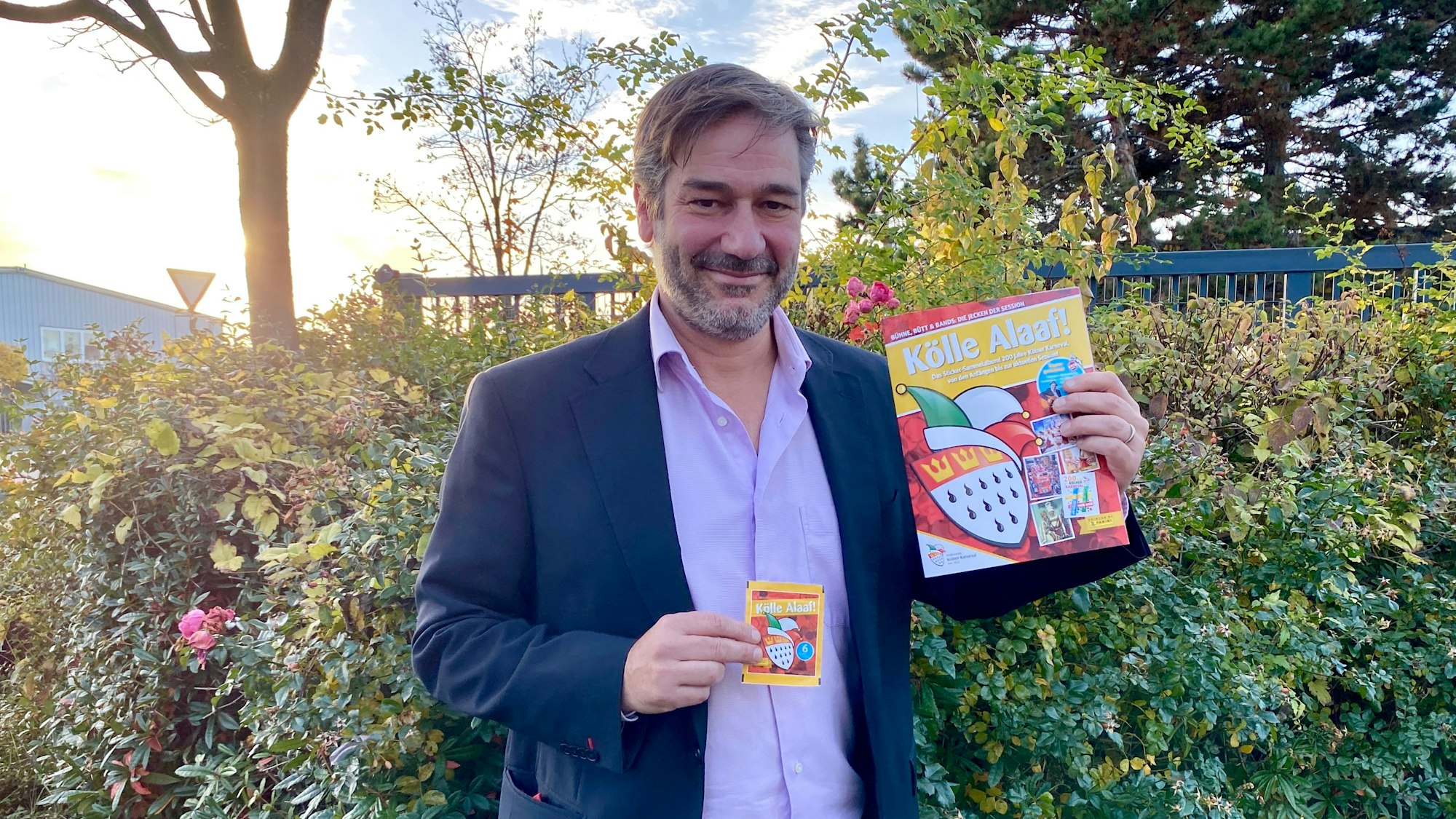 Thomas Schmitz hält das Panini-Album in der Hand.