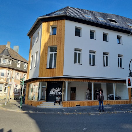 Blick auf ein dreistöckiges Geschäftshaus mit leerem Ladenlokal im Erdgeschoss.