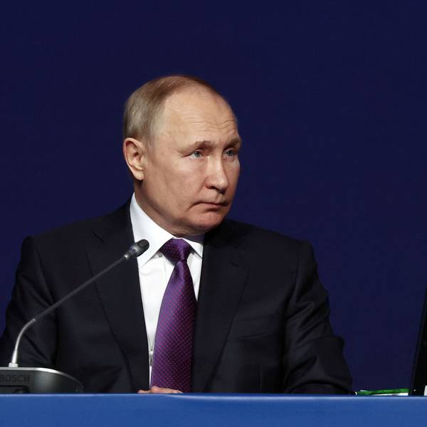 Der russische Präsident Wladimir Putin sitzt bei einer Konferenz an einem Tisch.