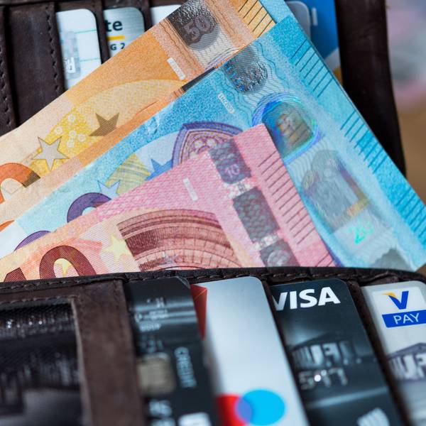 Banknoten und Bankkarten liegen in einer Geldbörse.