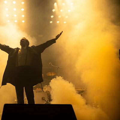 Kraftklub-Frontmann Felix Brummer steht mit ausgestreckten Armen auf der Bühne.