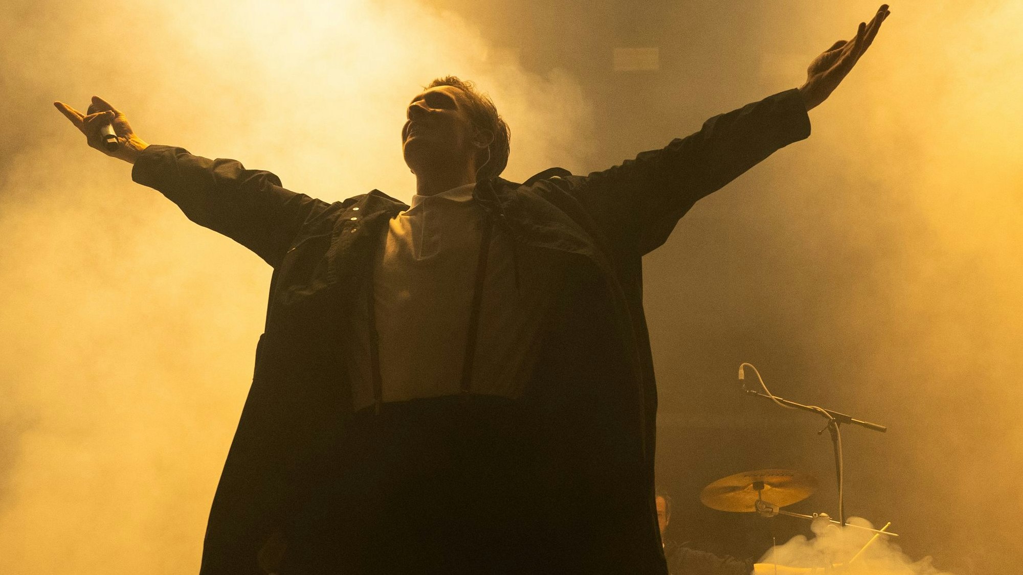 Kraftklub-Frontmann Felix Brummer steht mit ausgestreckten Armen auf der Bühne.