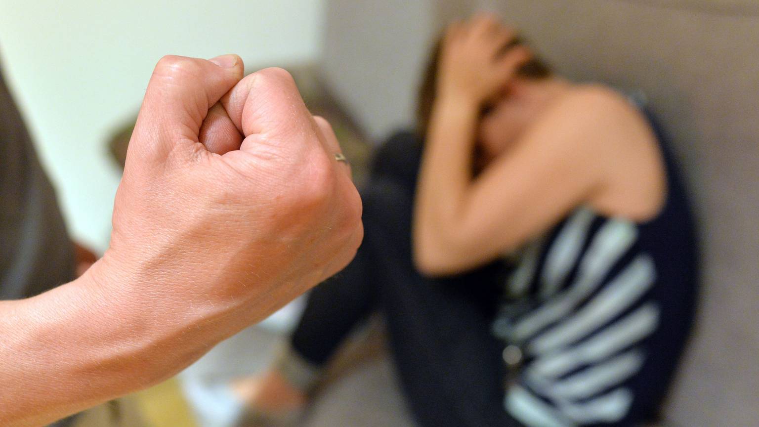 Eine Frau versucht, sich vor der Gewalt eines Mannes zu schützen (gestellte Szene).