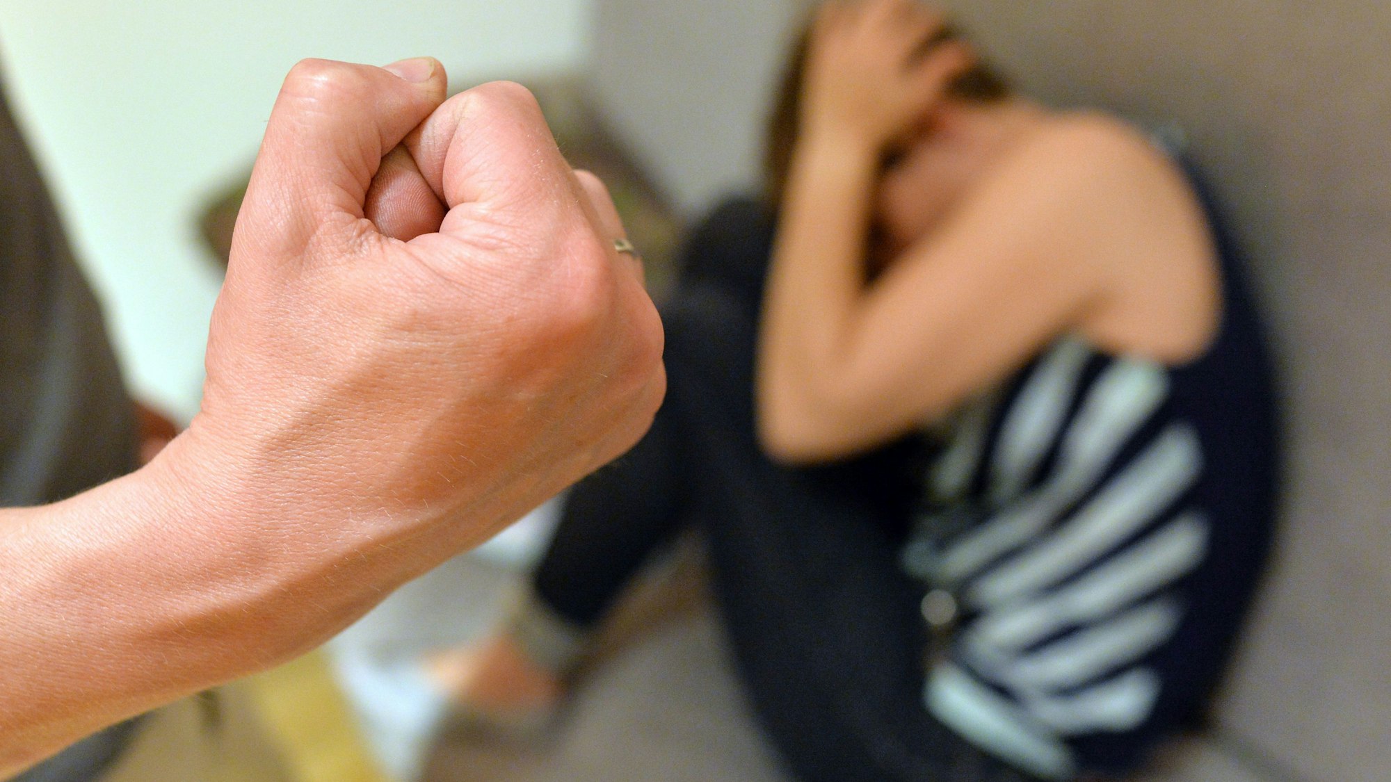 Eine Frau versucht, sich vor der Gewalt eines Mannes zu schützen (gestellte Szene).