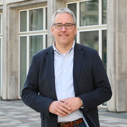Das Bild zeigt SPD-Fraktionschef Christian Joisten vor dem Spanischen Bau in der Innenstadt.