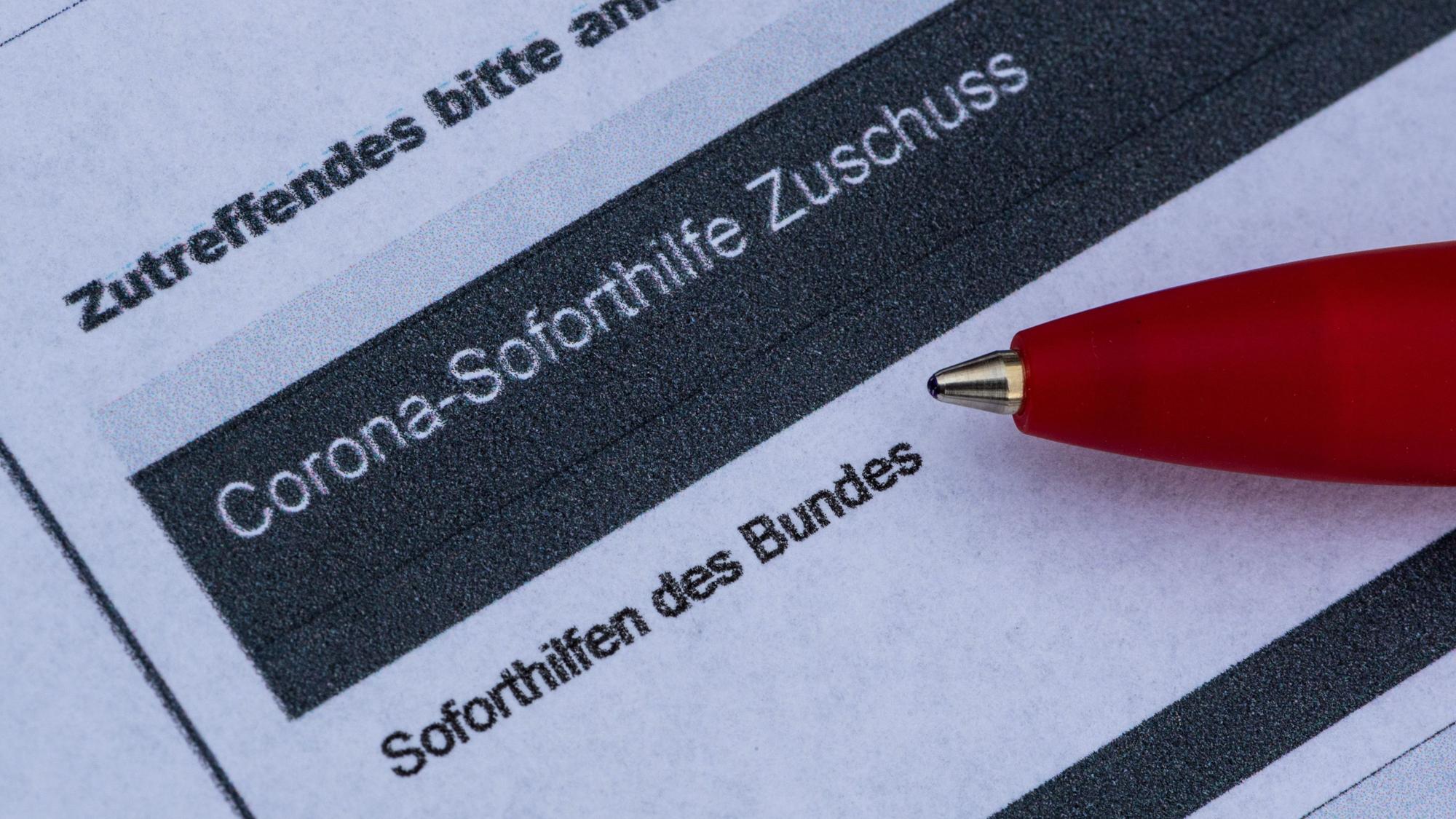 Ein Stift liegt auf einem Antrag für den Corona-Soforthilfe-Zuschuss.