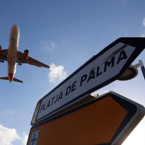 Palma: Ein Flugzeug überfliegt bei der Landung auf Mallorca ein Schild, das die Richtung nach Playa de Palma anzeigt. Auf einem Flug nach Mallorca haben fünf Deutsche einem Passagier das Leben gerettet.