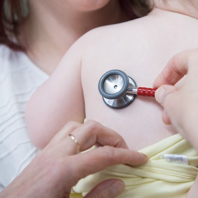 Eine Kinderärztin untersucht ein Kind mit einem Stethoskop.