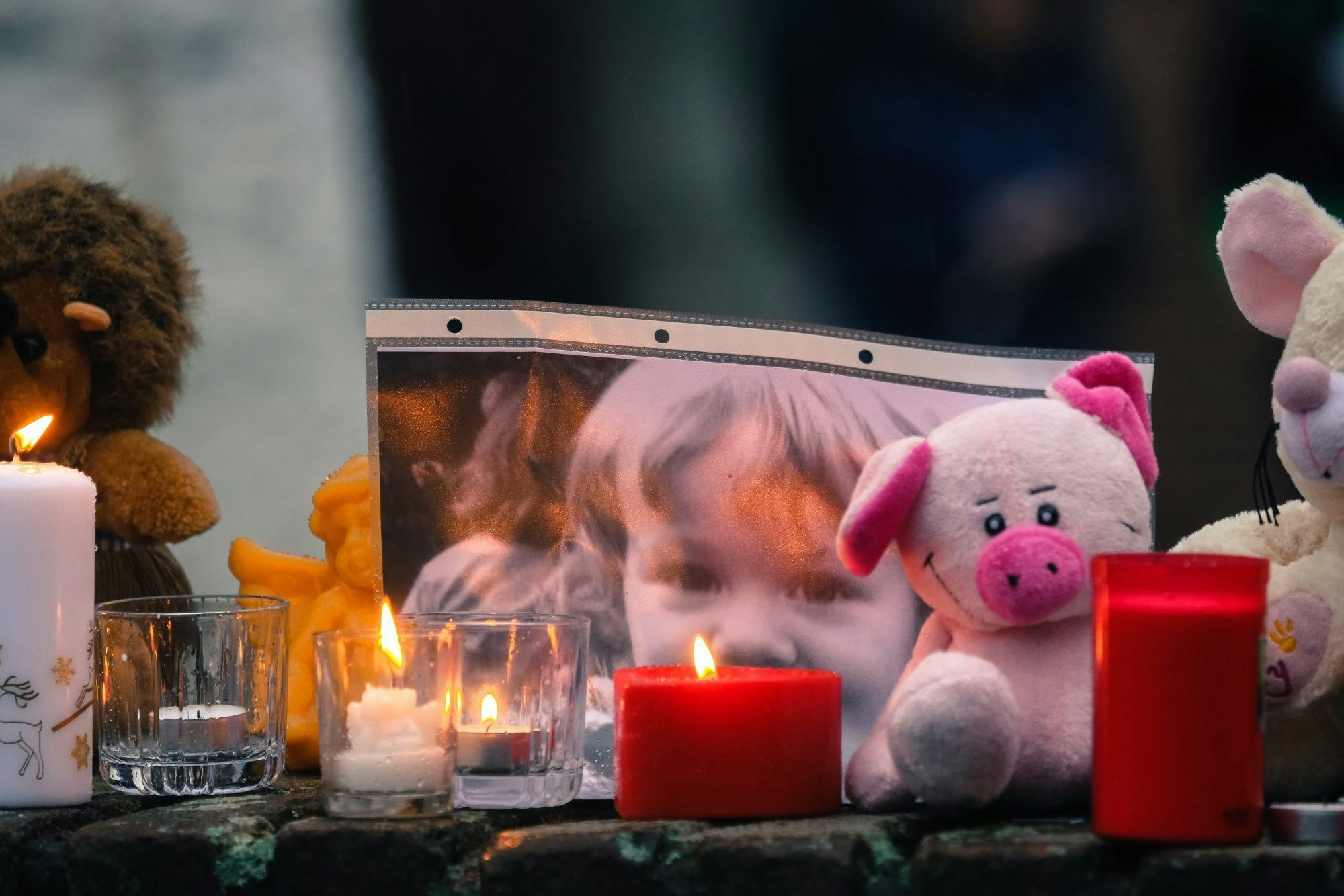 Kerzen, Stofftiere und ein Bild der ermordeten Lea Sofie sind auf einer Mauer am Pariser Platz in Chorweiler aufgestellt worden