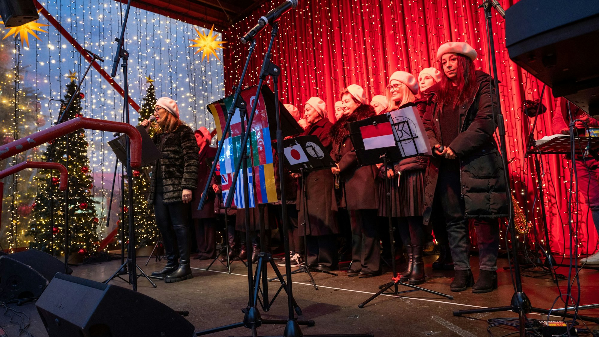 Der Kölner Frauenchor Aynur & 3K steht auf der Bühne des Weihnachtsmarkts auf dem Roncalliplatz.
