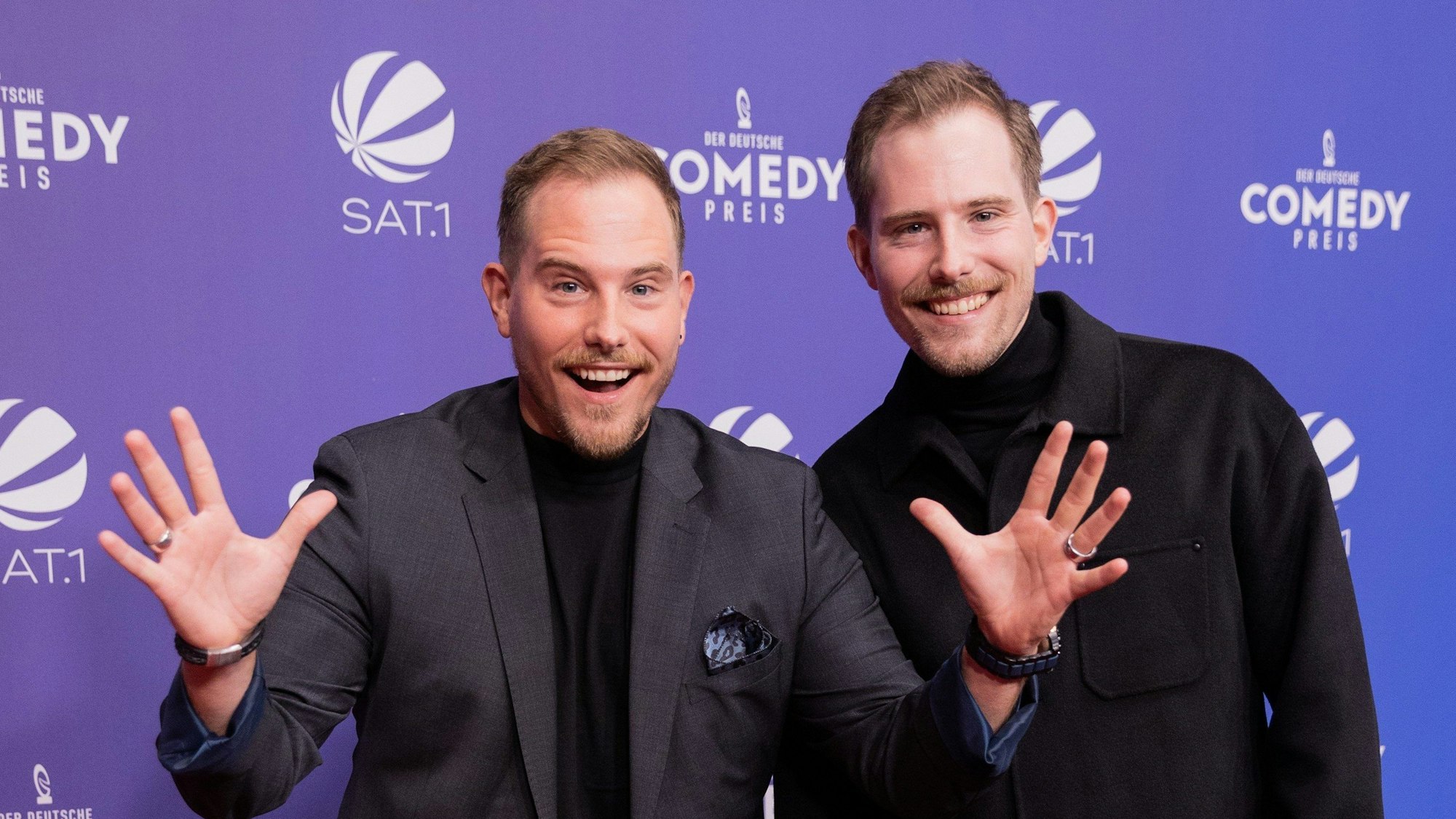 Die Zwillinge Benjamin (l) und Dennis Wolter, Youtuber, auf dem Roten Teppich zur Verleihung des „Deutschen Comedypreises“. Sie grinsen in die Kamera. Benjamin gestikuliert mit seinen Händen.