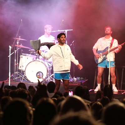 Planschemalöör in blauen Badehosen und weißen Oberteilen bei einem Konzert in Köln auf der Bühne.