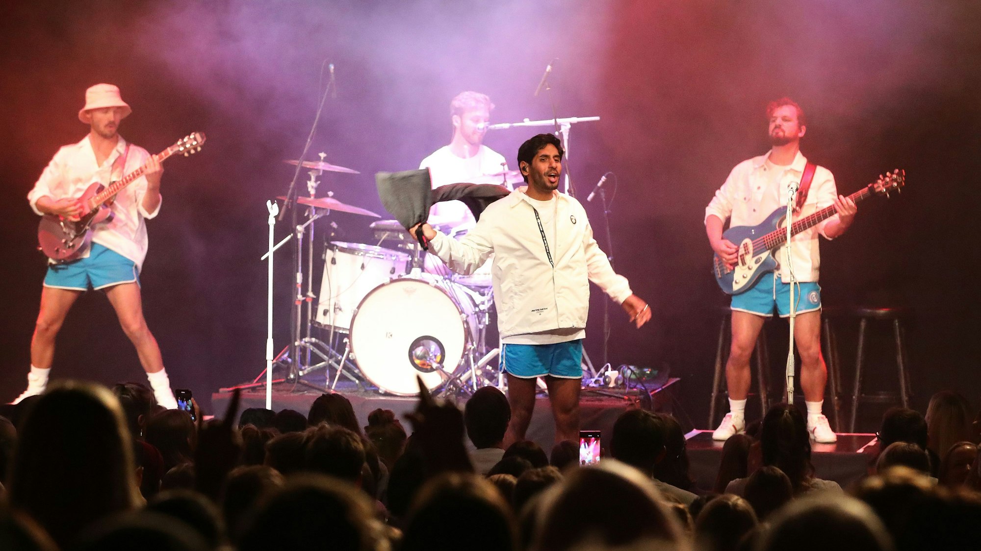 Planschemalöör in blauen Badehosen und weißen Oberteilen bei einem Konzert in Köln auf der Bühne.