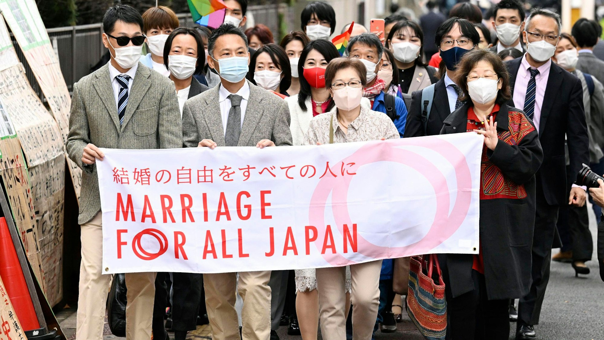 Unterstützer der „Ehe für alle“ laufen zum Bezirksgericht in Tokio. Sie halten ein Banner mit der Aufschrift „Ehe für ganz Japan“ hoch.