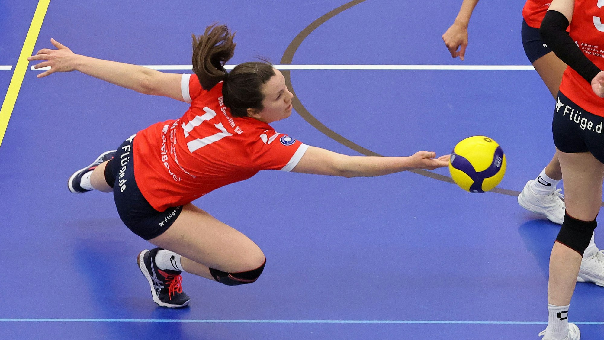 Eine Volleyballspielerin wirft sich dem Ball entgegen.