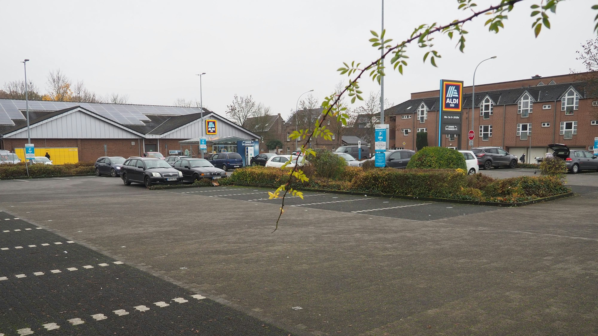 Auf dem Aldi-Parkplatz an der Köttinger Straße soll ein Drogeriemarkt entstehen. Im Hintergrund sieht man den Aldi-Markt, davor ist der Parkplatz zu sehen.