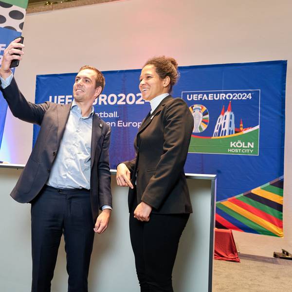 Der Fußballer Philipp Lahm steht links neben Celia Šašić. In seiner ausgestreckten Hand hält er ein Smartphone, um ein Selfie zu machen.