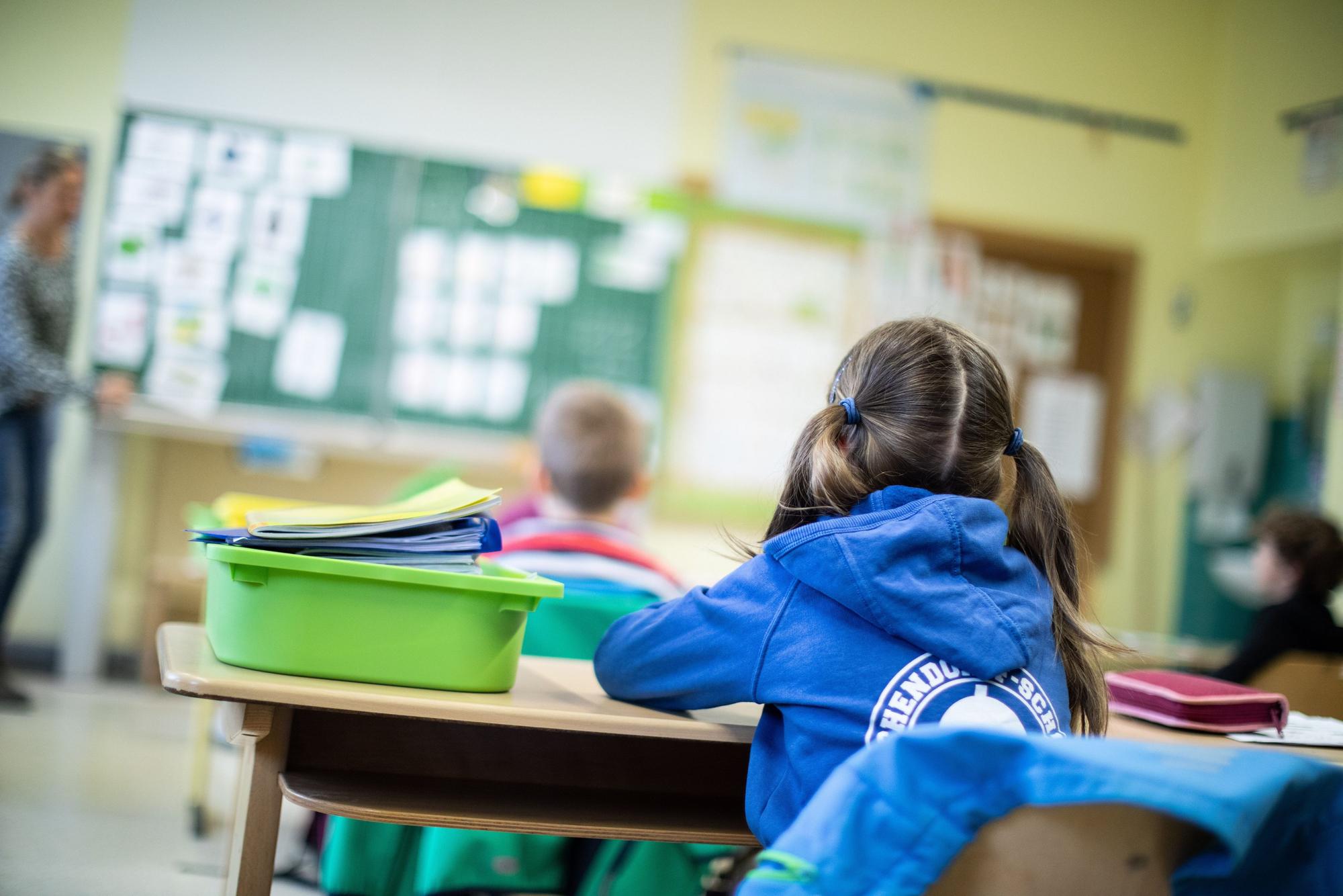 Schülerinnen und Schüler sitzen im Klassenraum einer Grundschule.