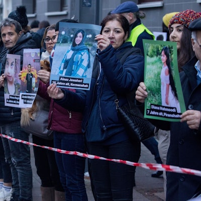 Kundgebung vor der Zentrale von Unicef Deutschland, die an das Schicksal von getöteten Kindern im Iran erinnern soll. Mehrere Menschen halten Plakate von den Kindern hoch.