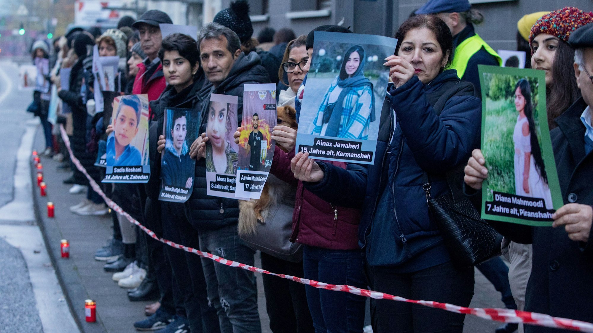 Kundgebung vor der Zentrale von Unicef Deutschland, die an das Schicksal von getöteten Kindern im Iran erinnern soll. Mehrere Menschen halten Plakate von den Kindern hoch.
