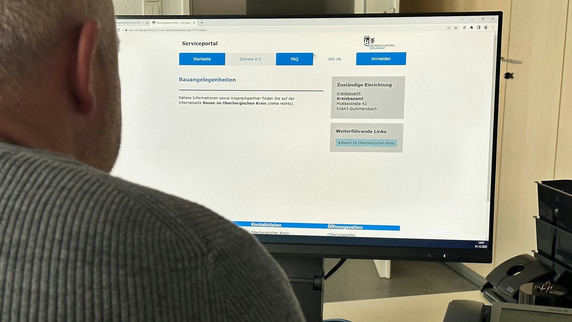 Ein Mann sitzt vor einem Computer-Bildschirm, auf dem die neue Seite des Bauamts zu sehen ist.