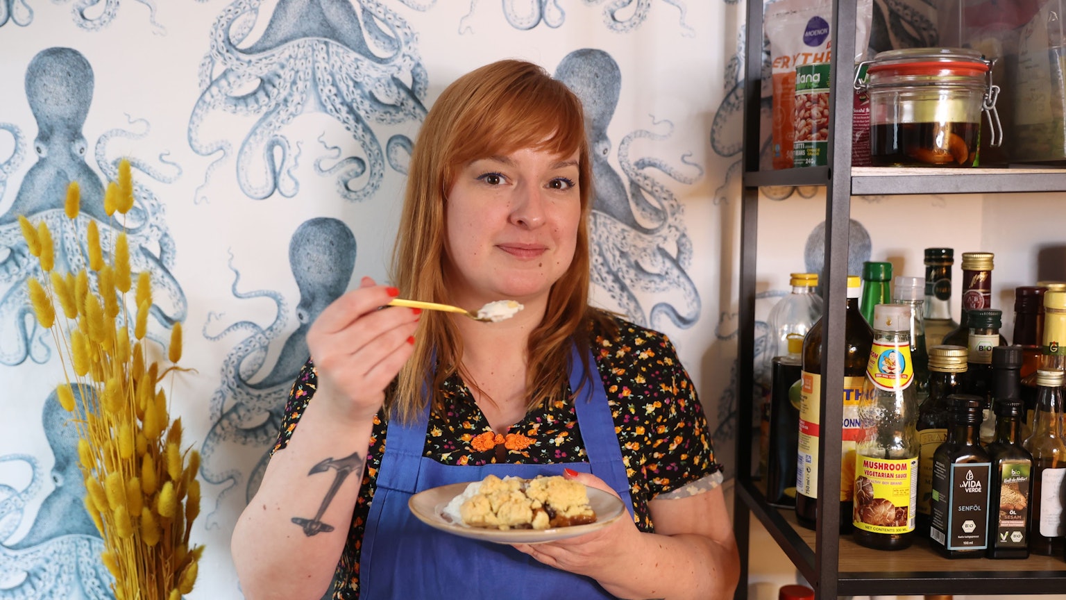 Julia Floß mit einem Teller Dessert in der Hand.