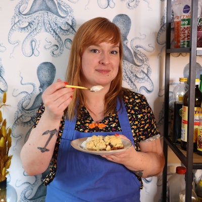 Julia Floß mit einem Teller Dessert in der Hand.