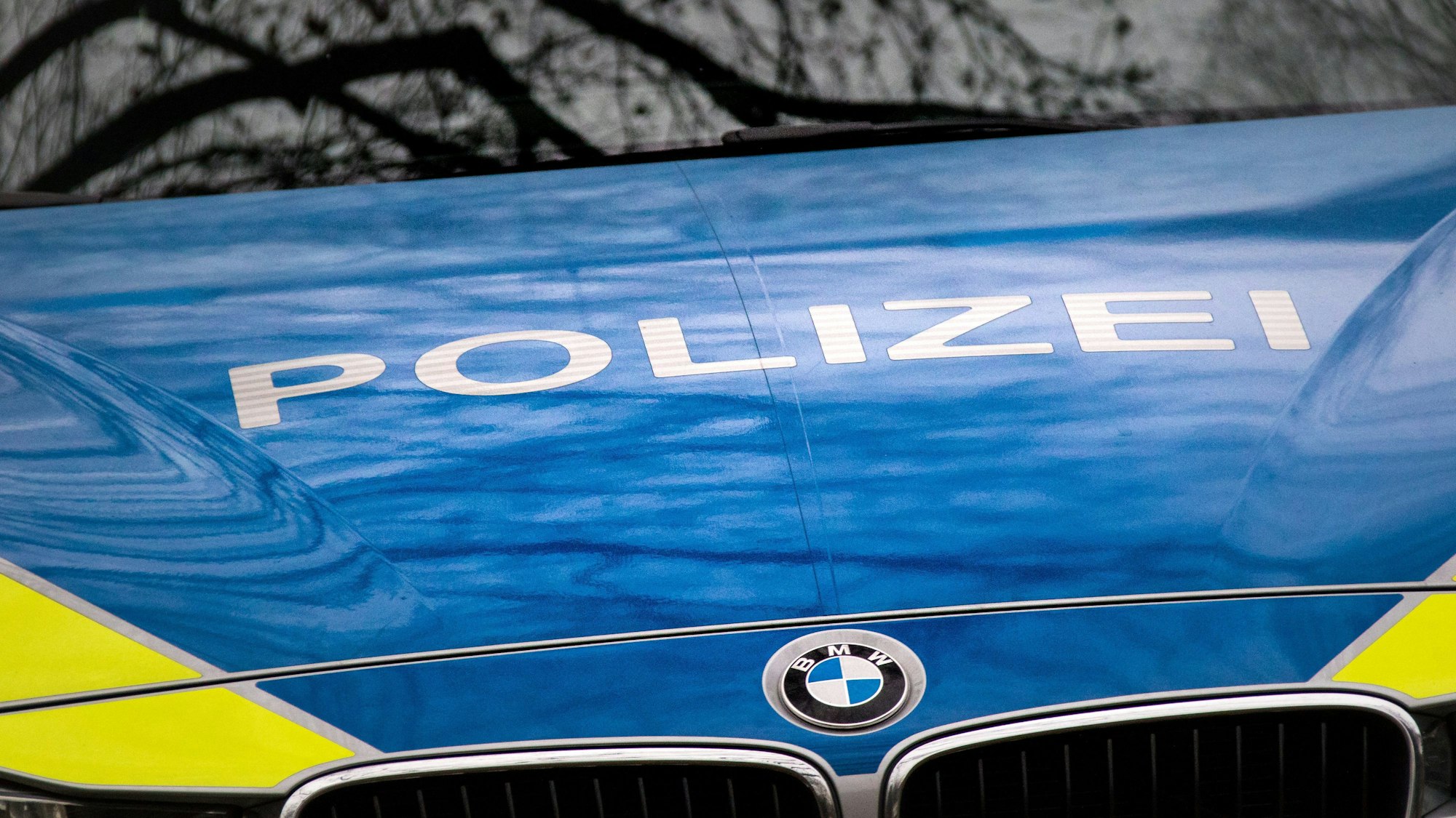 Der Schriftzug „Polizei“ ist auf einem Streifenwagen zu sehen.