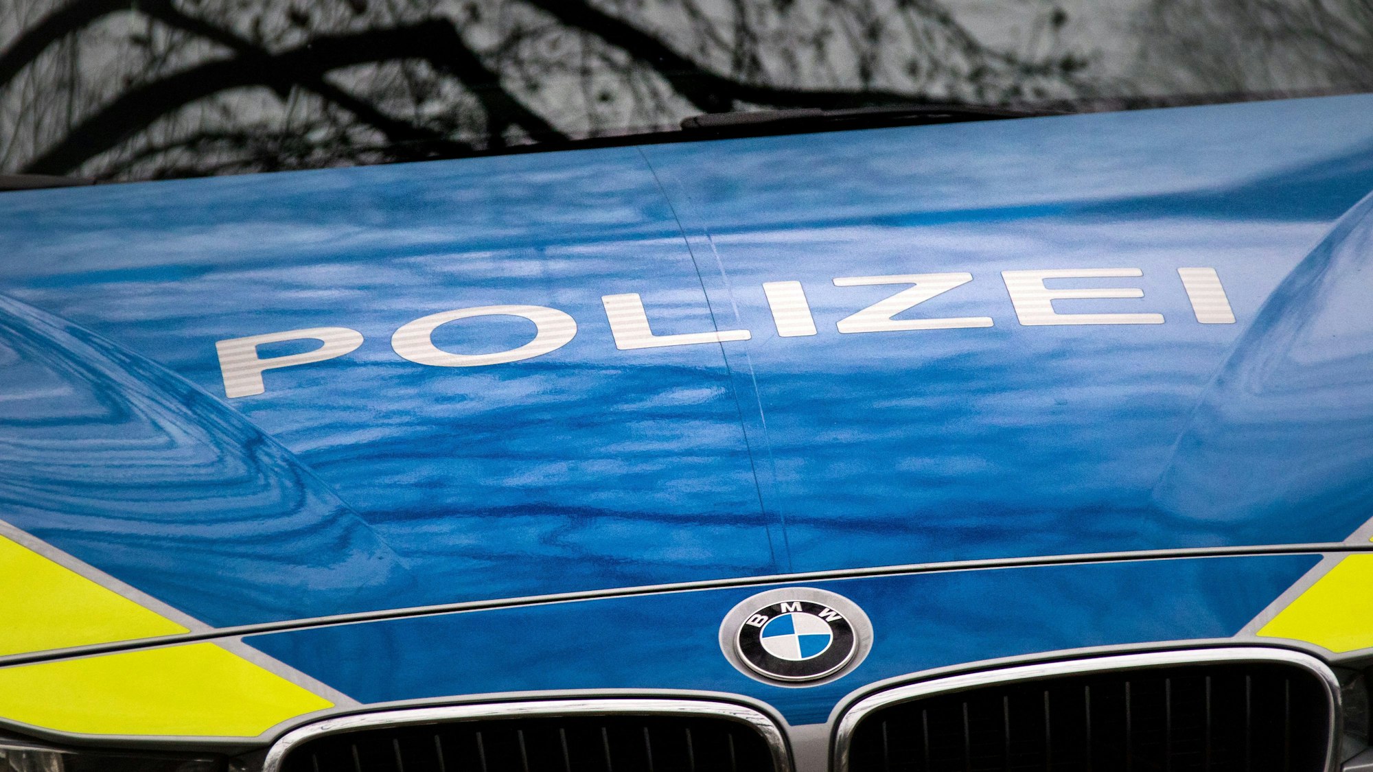 Der Schriftzug "Polizei" ist auf der Motorhaube eines Streifenwagens zu sehen.