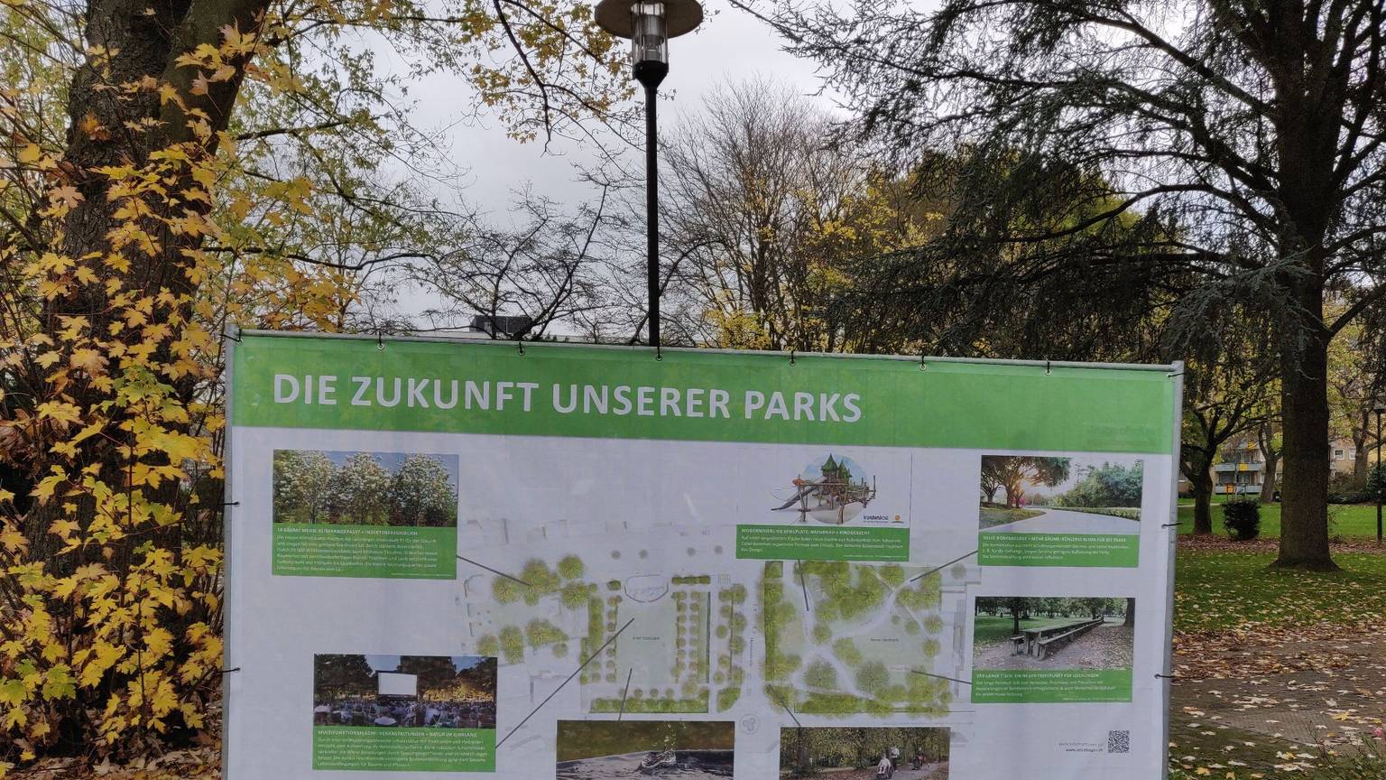 Ein großes Transparent mit Fotos, Planskizzen und Erläuterungen zur Umgestaltung steht an der Baustelle im Leichlinger Stadtpark.