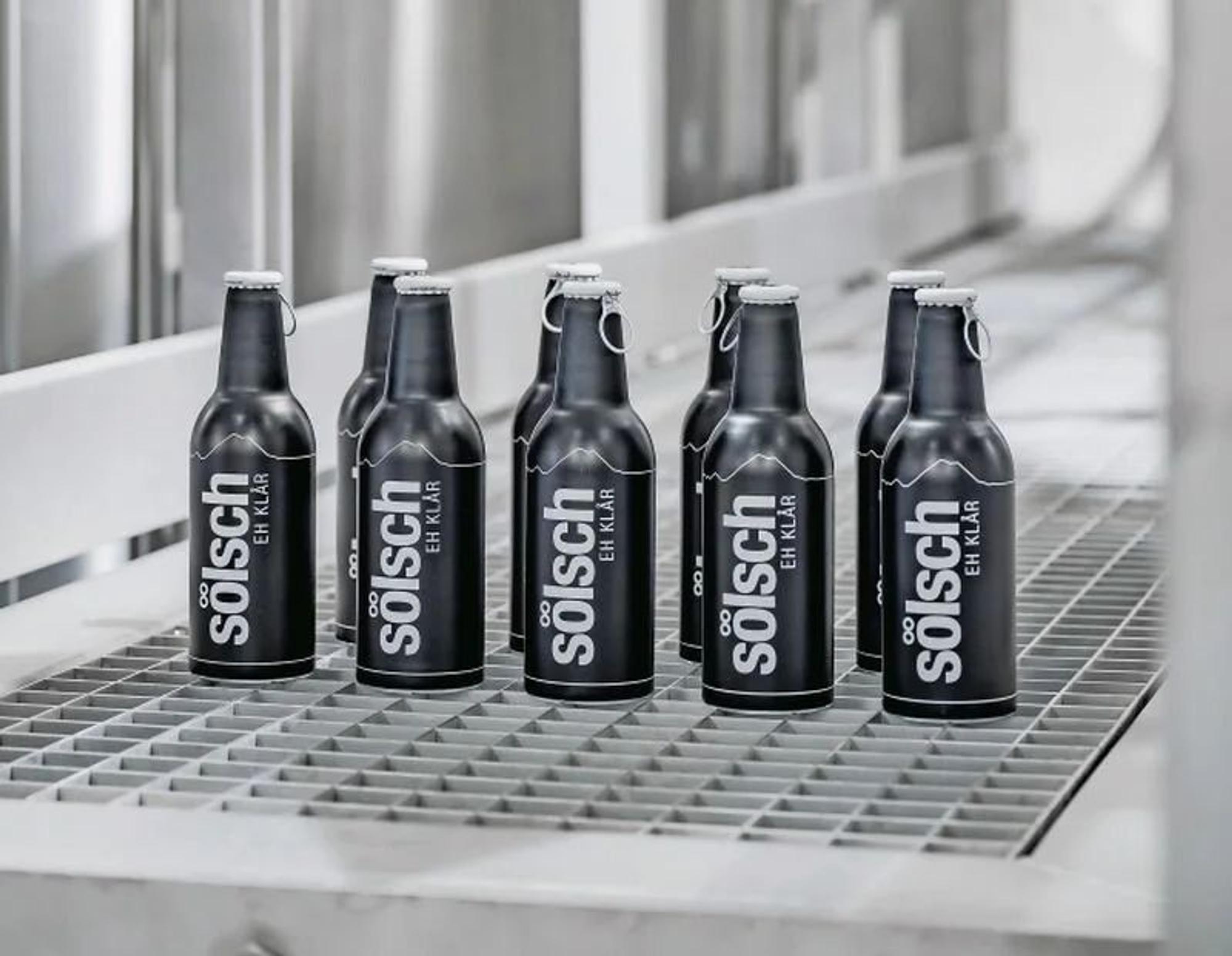 Einige Flaschen Sölsch stehen auf dem Boden.