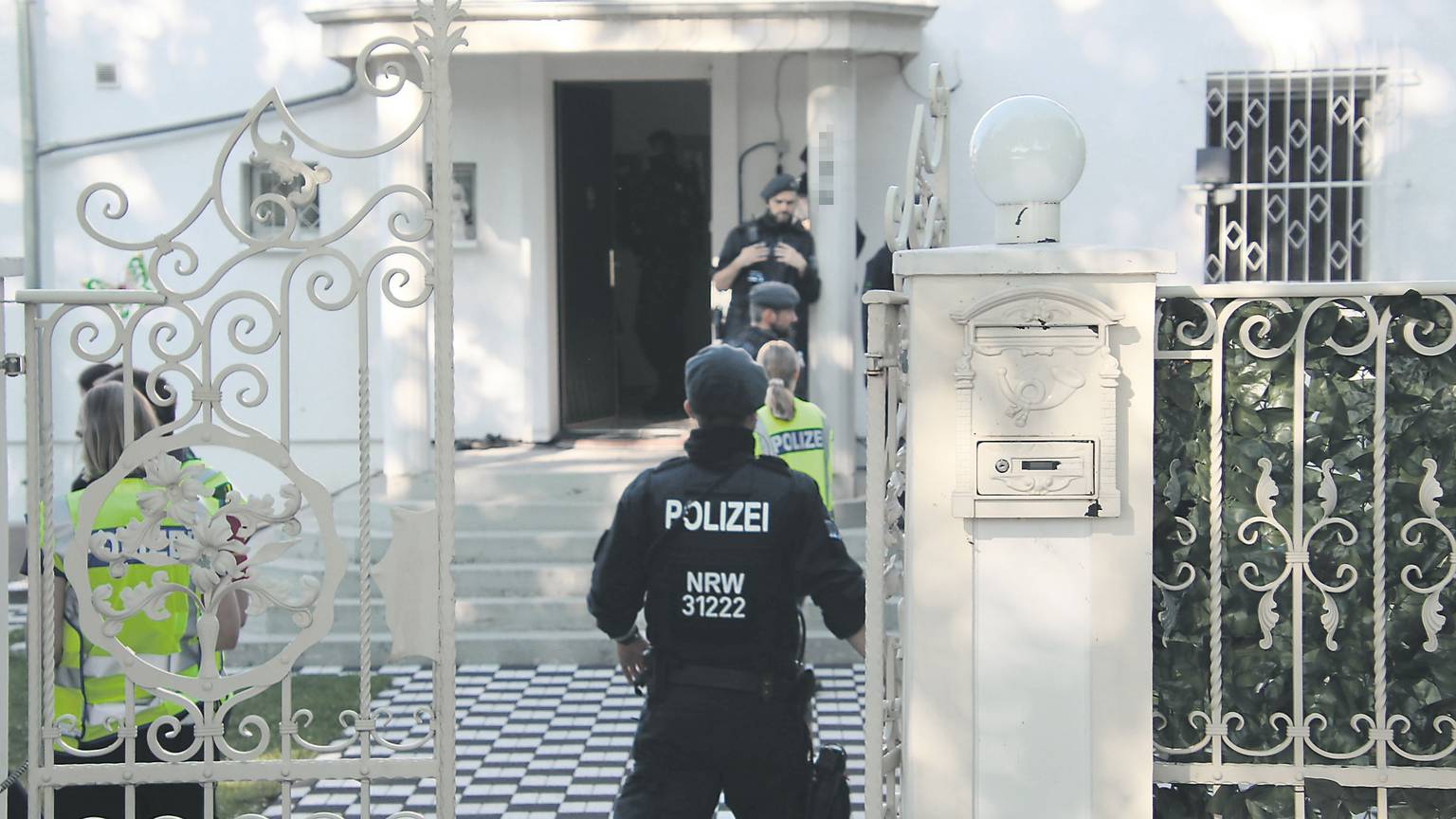 Polizisten bei einer Razzia vor einer Villa im Kölner Stadtteil Ostheim