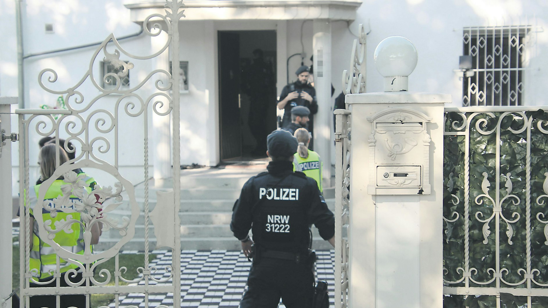 Polizisten bei einer Razzia vor einer Villa im Kölner Stadtteil Ostheim