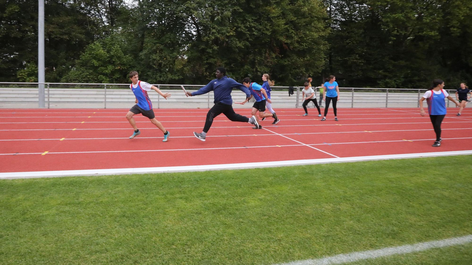 Staffellauf der GSV Leichtathleten zur Einweihung des neuen Sportplatzes. Auf dem Bild übergibt ein Läufer den Staffelstab an seinen Vordermann.