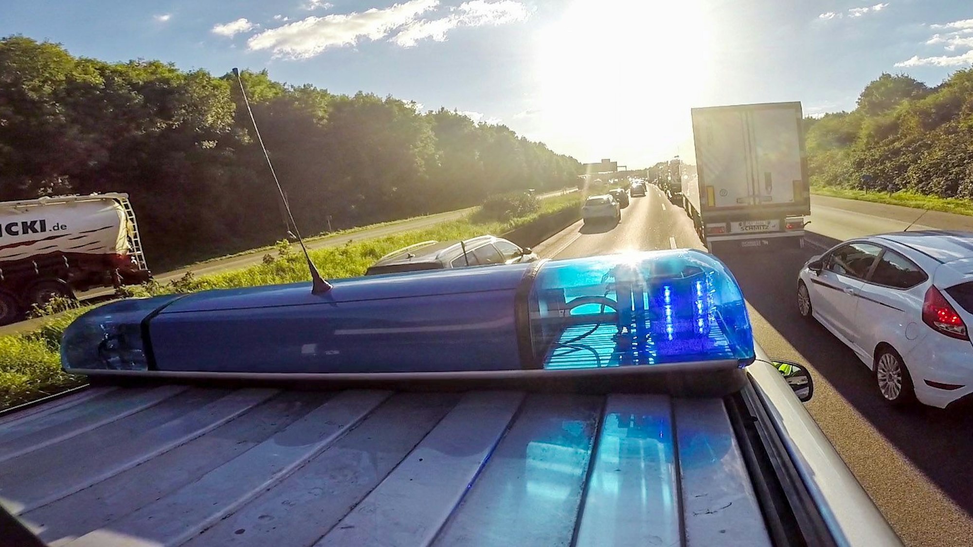 Ein Streifenwagen der Autobahnpolizei Köln fährt mit Blaulicht und Martinshorn über die Autobahn.