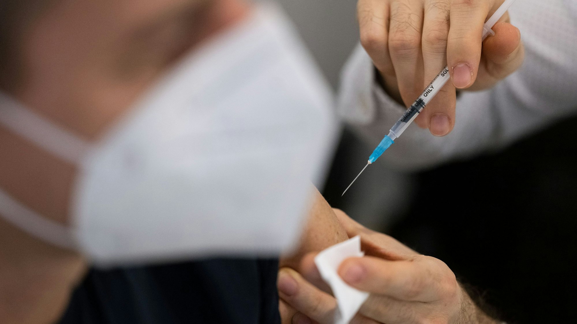 18.10.2022, Baden-Württemberg, Stuttgart: Ein Mann wird in einem Impfzentrum in der Innenstadt mit dem an die Corona-Variante Omikron BA.4-5 angepassten Comirnaty-Wirkstoff von Biontech geimpft. In Baden-Württemberg haben sich zuletzt wieder mehr Menschen eine Corona-Auffrischungsimpfung geben lassen. Foto: Marijan Murat/dpa +++ dpa-Bildfunk +++