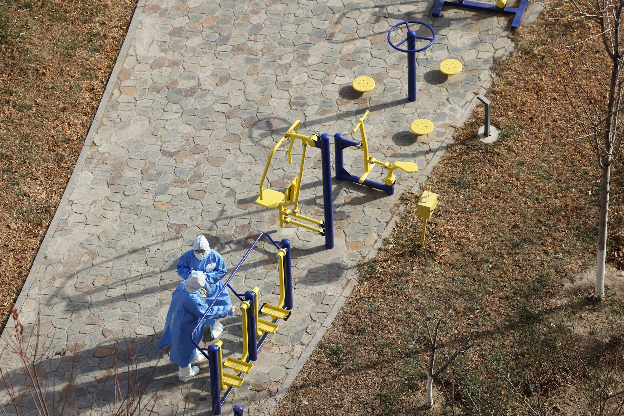 Chinesische medizinische Mitarbeiter nehmen Corona-Proben an einem Spielplatz.