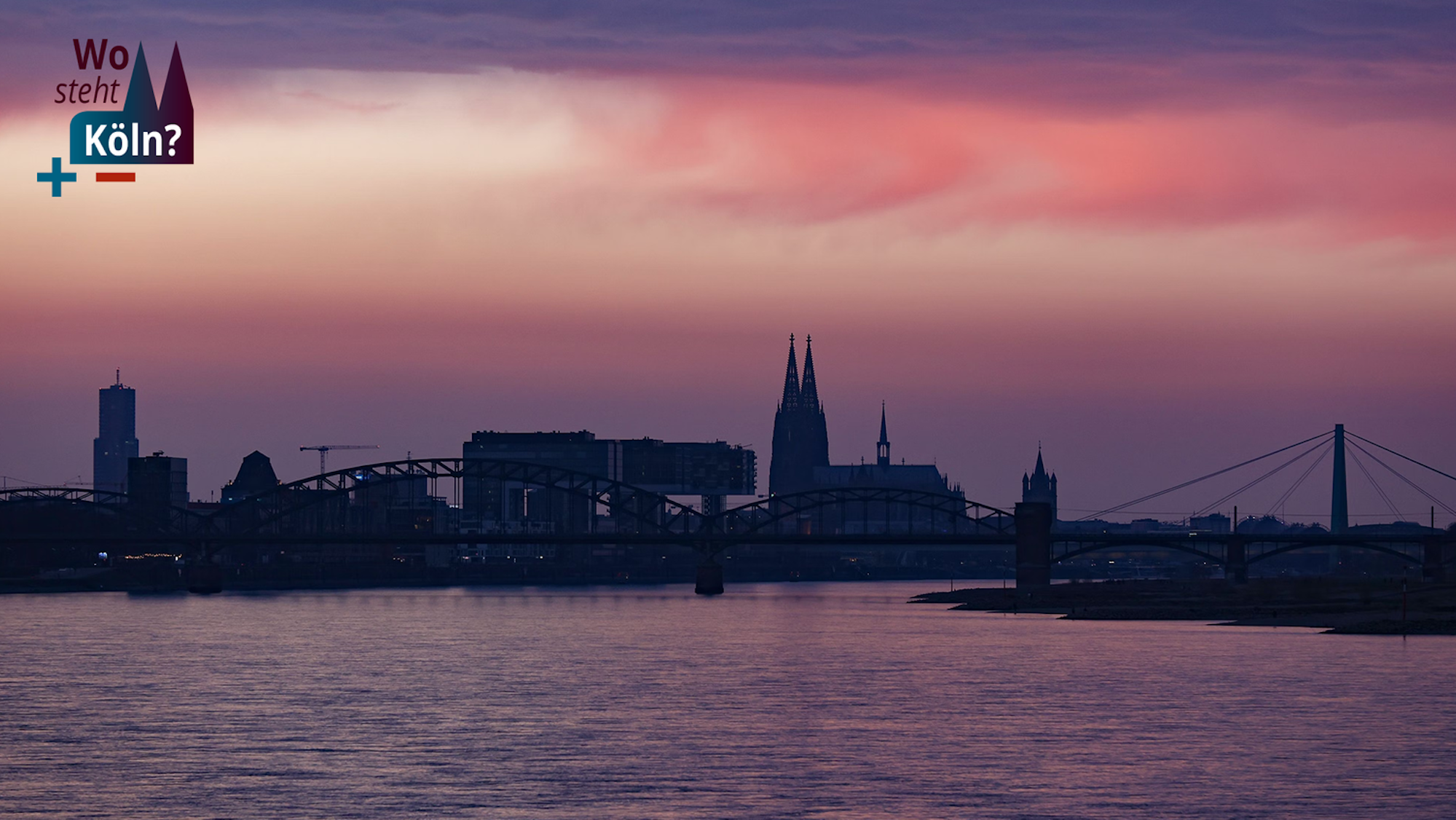 Das Bild zeigt den Blick auf Köln in der Dämmerung, zu sehen sind der Dom, die Brücken und die Kranhäuser.