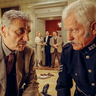 Chief Inspector Francis Lightmyer (Udo Wachtveitl, links vorne) und Constable Ivor Partridge (Miroslav Nemec, rechts vorne) untersuchen Arthur im Kaminzimmer. Lady Bantam (Sunnyi Melles), Charles (Ferdinand Hofer) und Dr. Mallard (Alexander Hörbe, rechts hinten) beobachten sie.