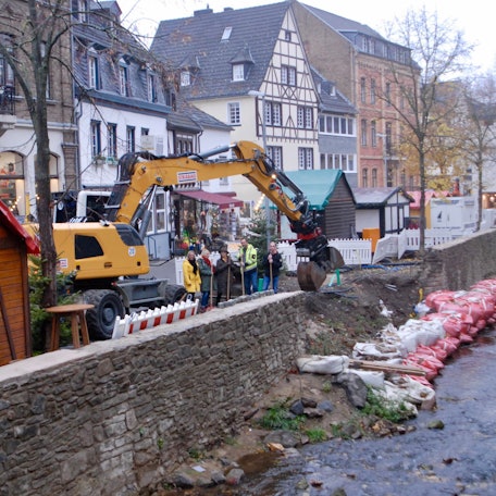 Ein Bagger steht an der Erft in Bad Münstereifel. Dort wird nun eine Freitreppe gebaut.