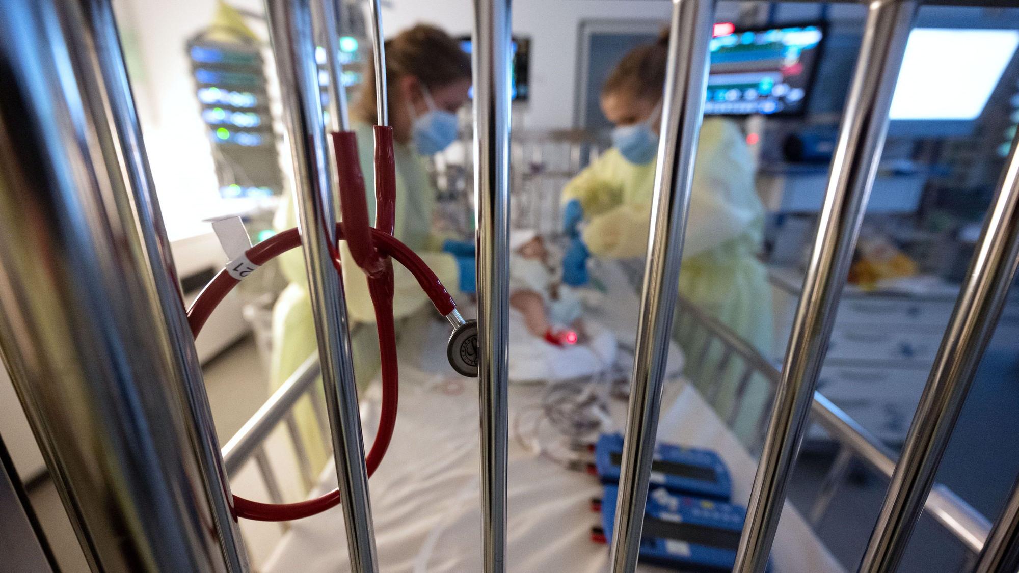 Intensivpflegerinnen versorgen auf einer Kinder-Intensivstation einen am RS-Virus erkrankten Säugling.