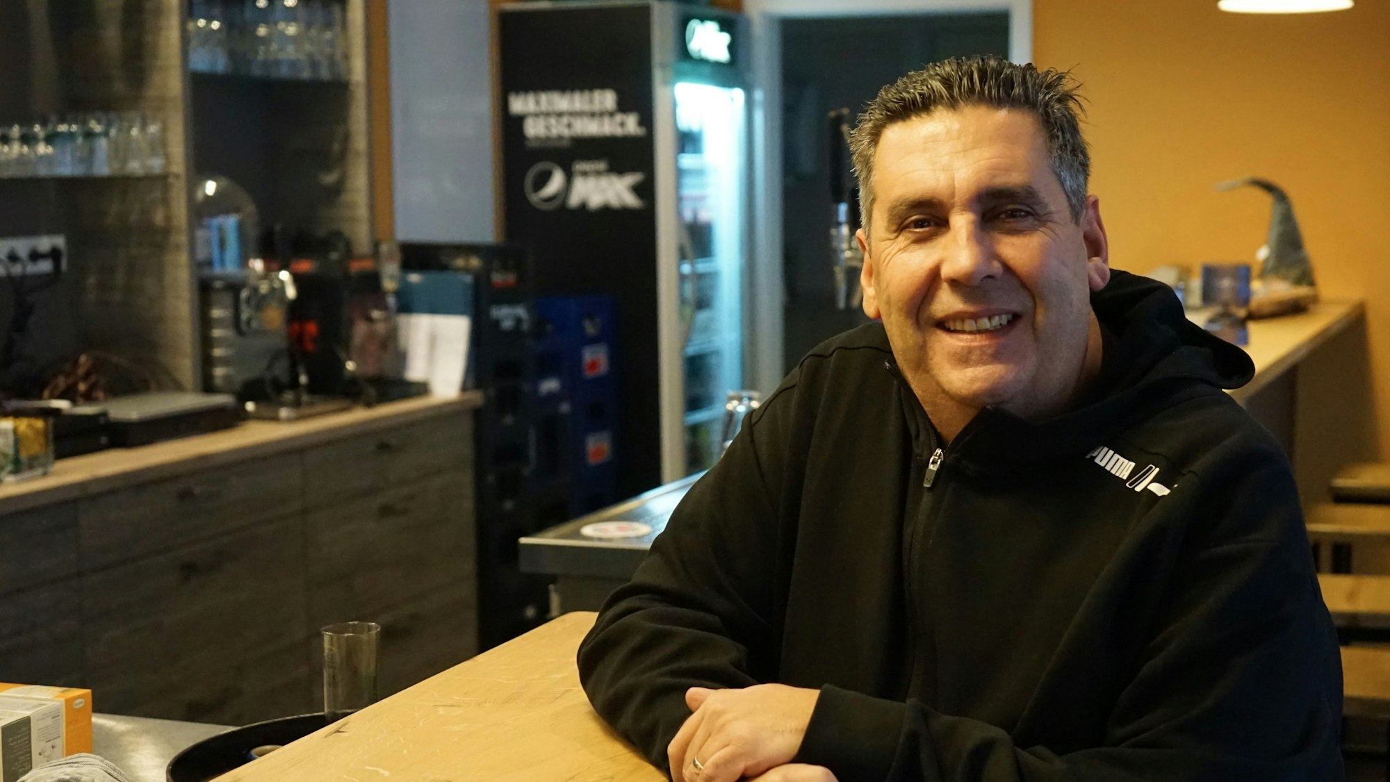 Gastronom Miguel Louzao de la Cruz lehnt am Tresen seines Bistros Picasso in Rösrath-Hoffnungsthal.