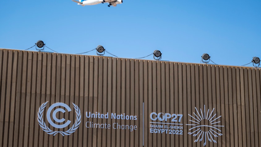 Ein Flugzeug fliegt beim UN-Klimagipfel COP27 über einen Konferenzraum mit dem Logo der COP27.