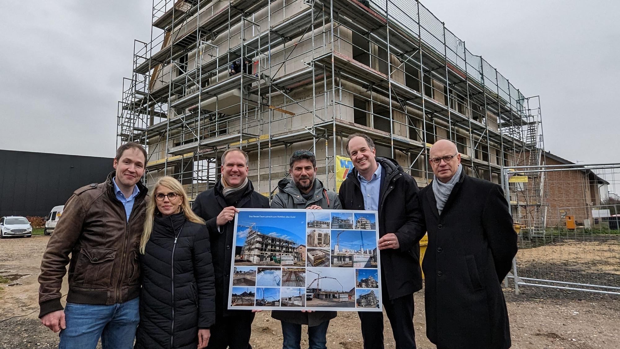 Die Projektverantwortlichen stehen vor dem Neubau des Wohnheims.