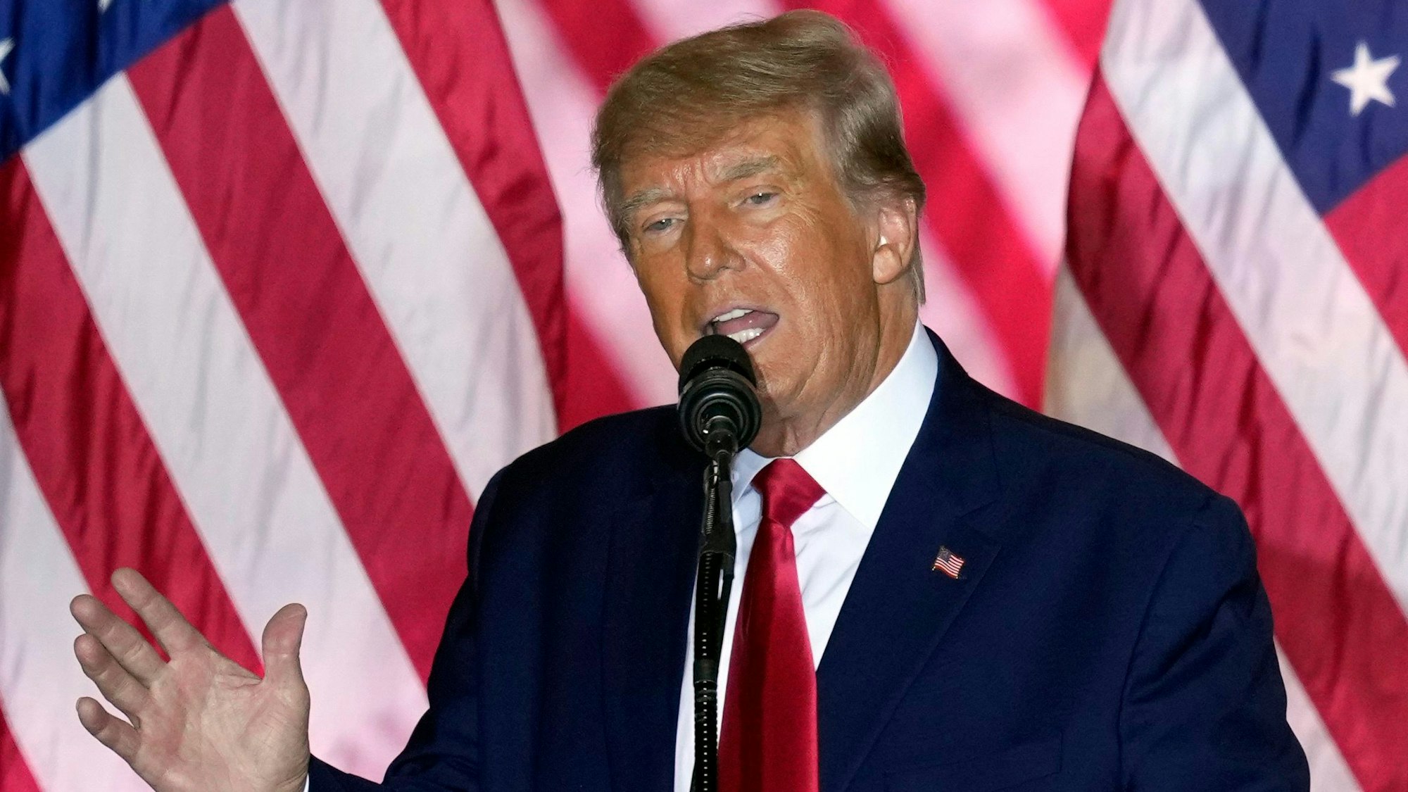Der ehemalige Präsident der USA, Donald Trump, hält eine Rede. Im Hintergrund ist eine amerikanische Flagge zu sehen.
