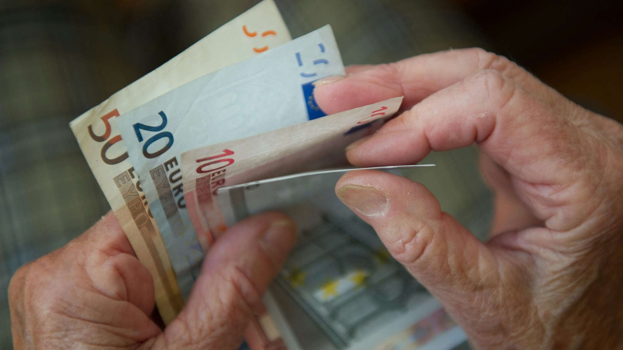 Eine ältere Frau zählt Geld.