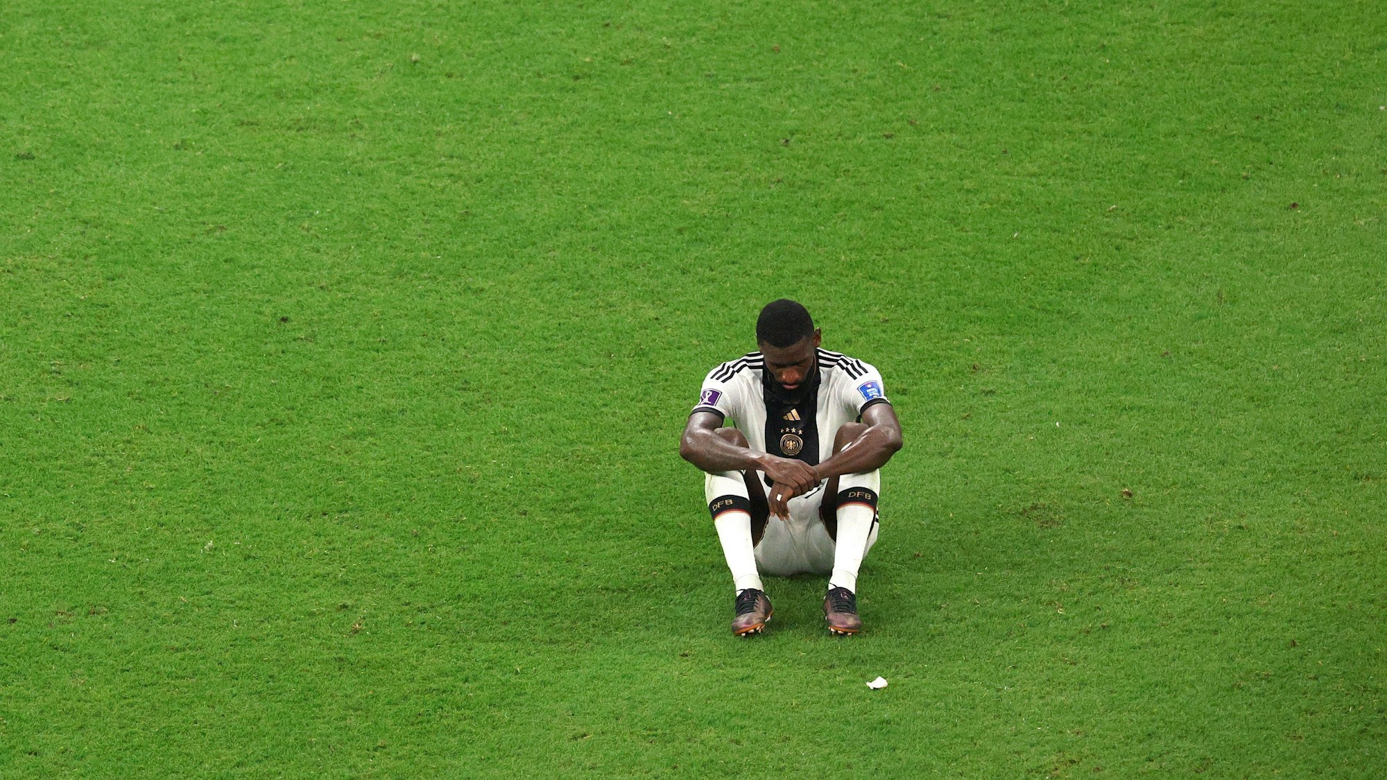 Antonio Rüdiger sitzt nach dem WM-Aus reg- und sprachlos auf dem Rasen.